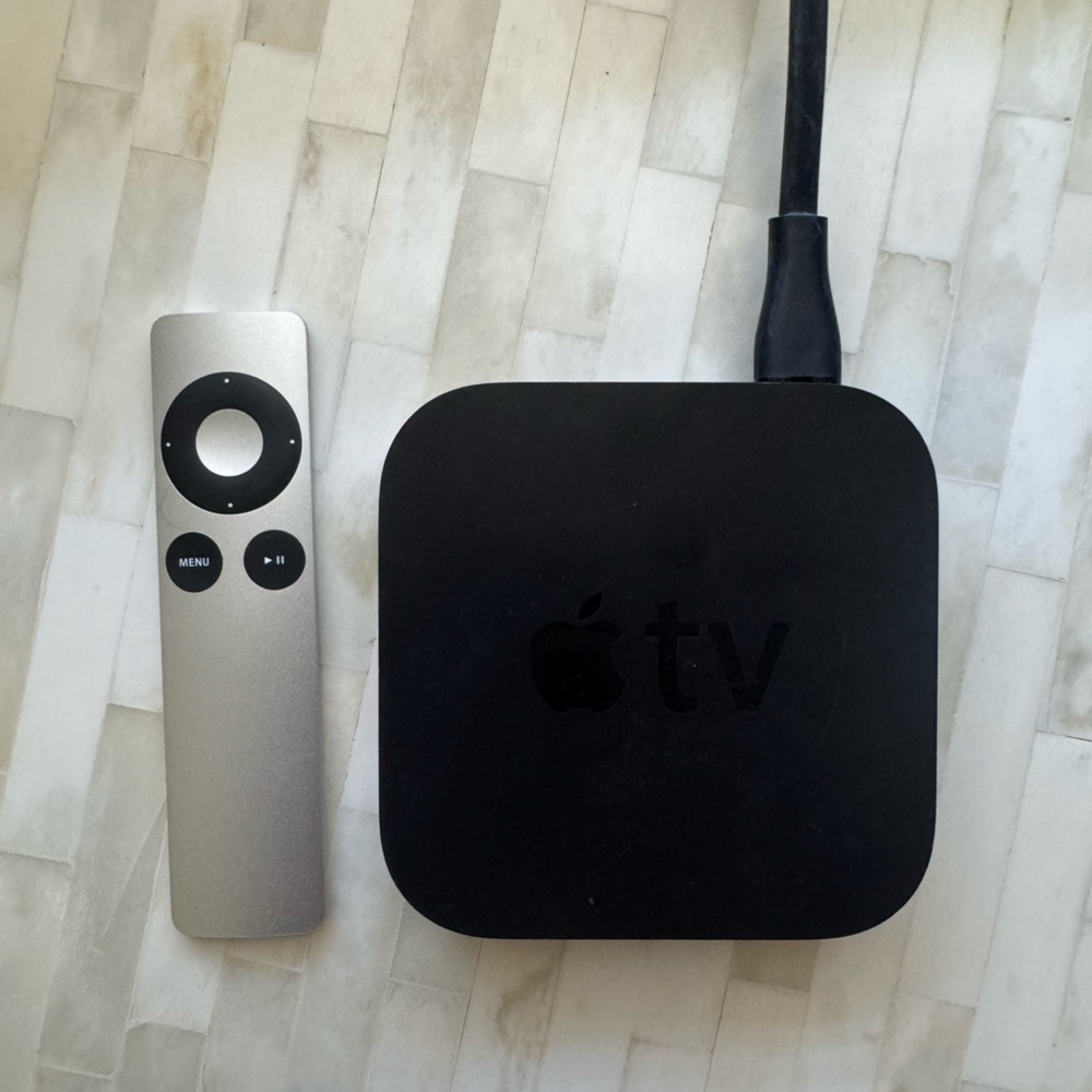 Apple Black TV Box with Silver Remote and chord.